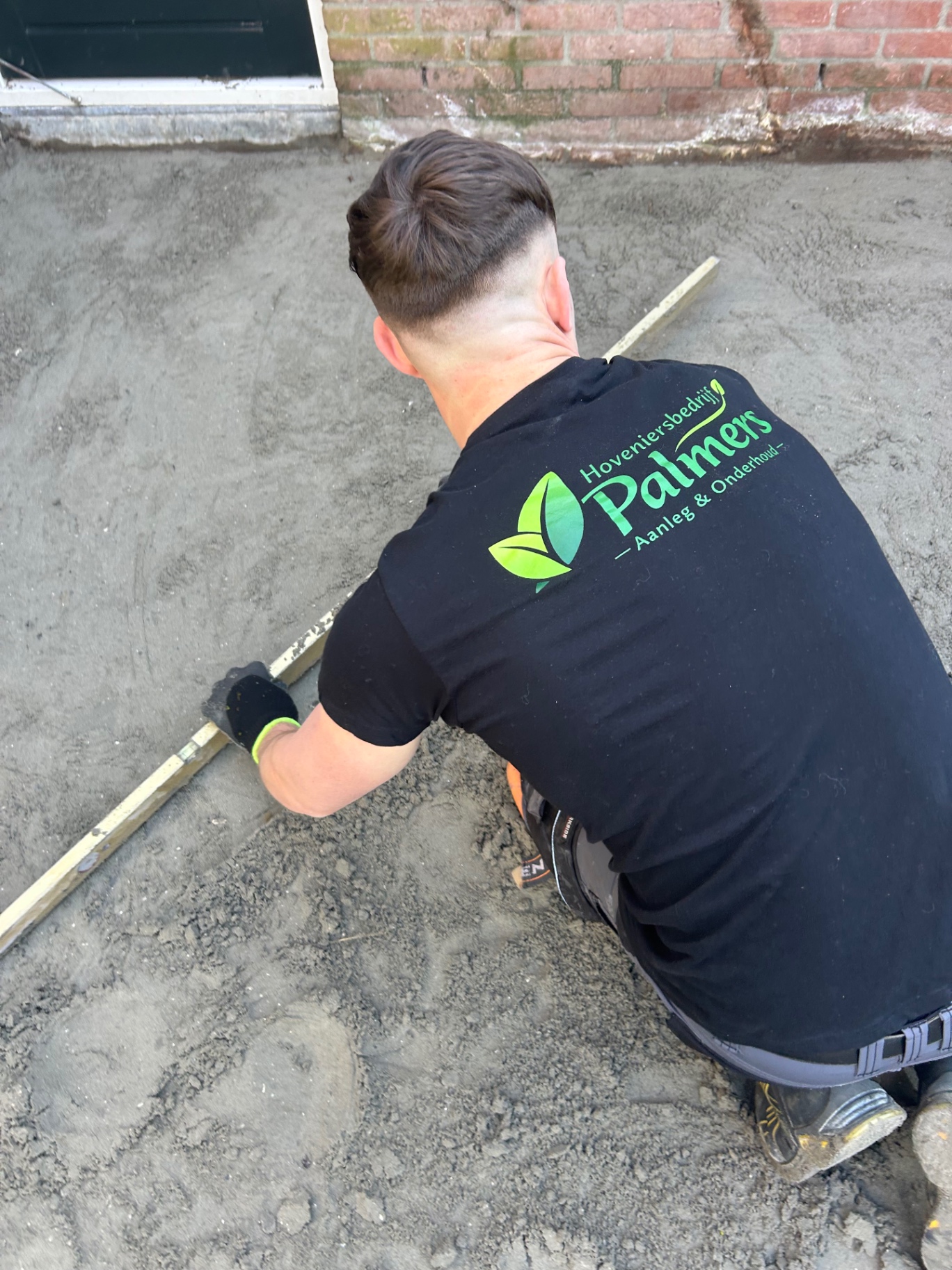 Medewerker van Palmers aan het werk tijdens een bestratingsproject